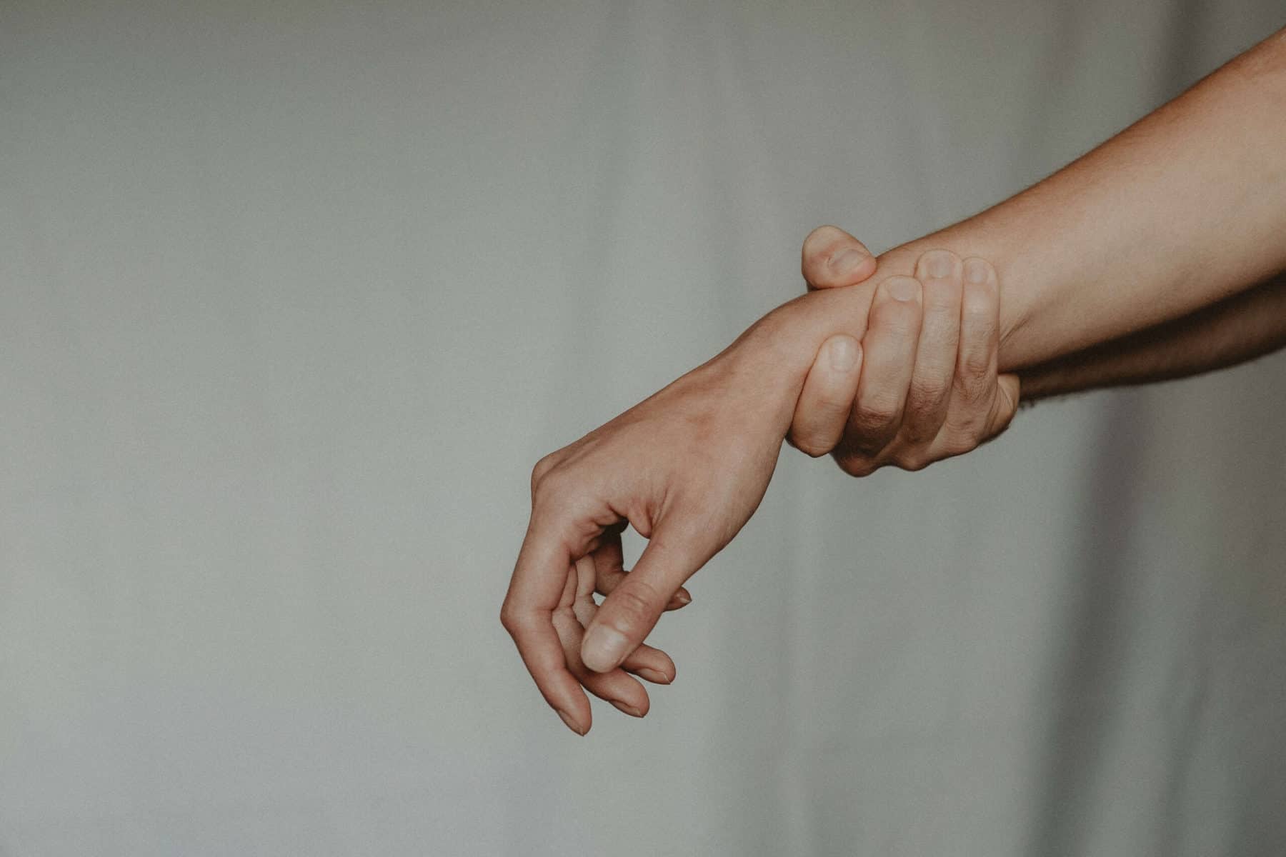 A close-up of a person holding their wrist