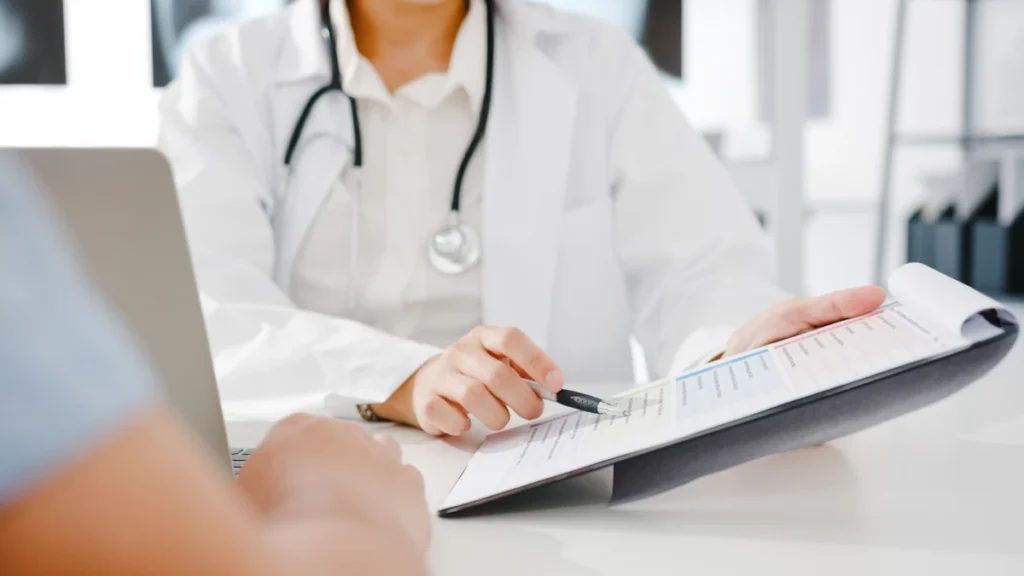Doctor reviewing and explaining a patient's medical report during a consultation.