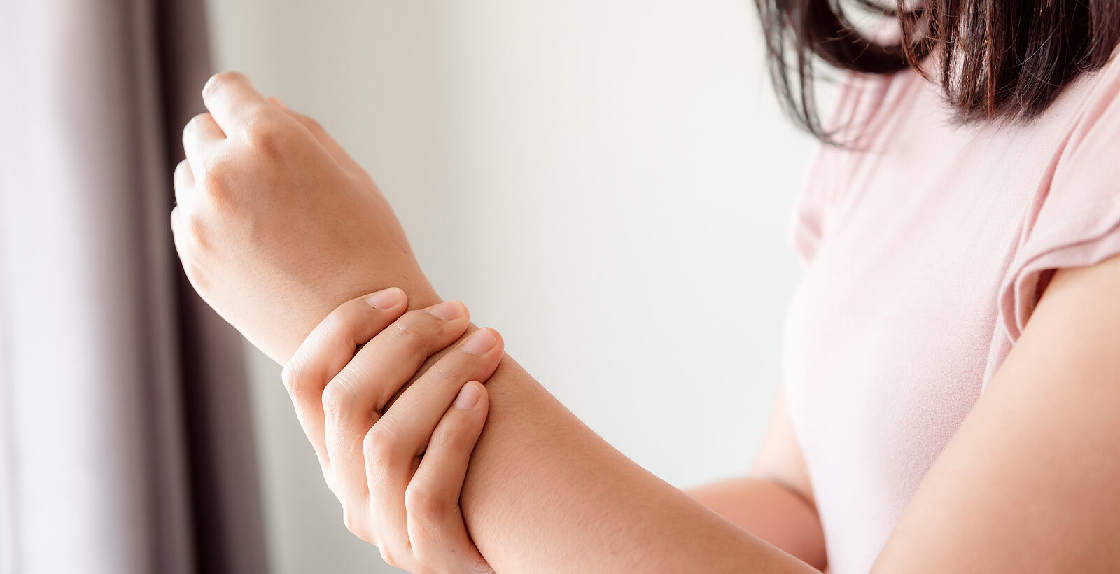 Girl holding her wrist in pain.