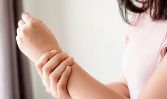 Girl holding her wrist in pain.