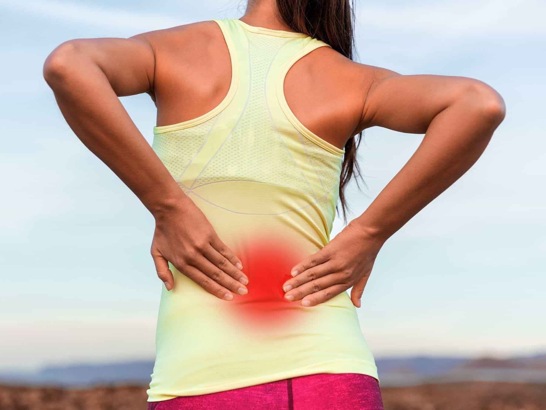 Woman with back pain holding her lower back
