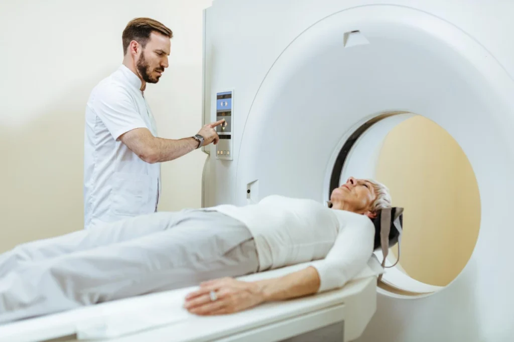 Patient undergoing MRI scan with technician operating the machine.