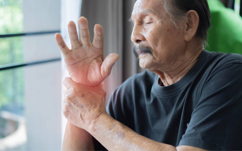 Elderly man holding his wrist in pain.