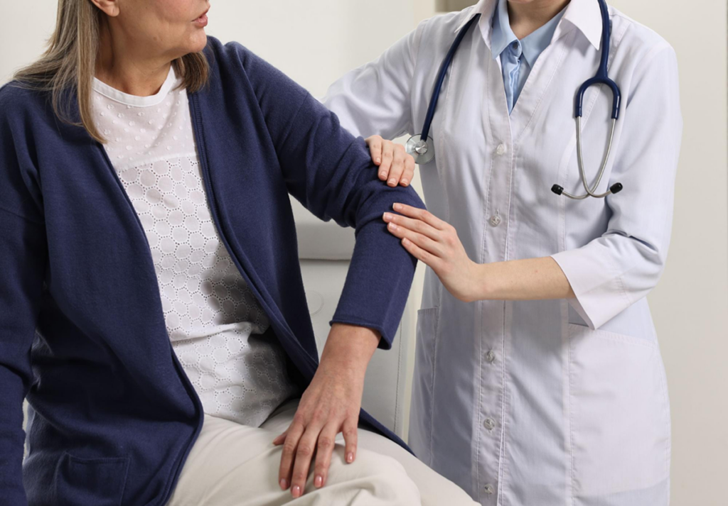 A doctor examines a patient's arm during a medical appointment.