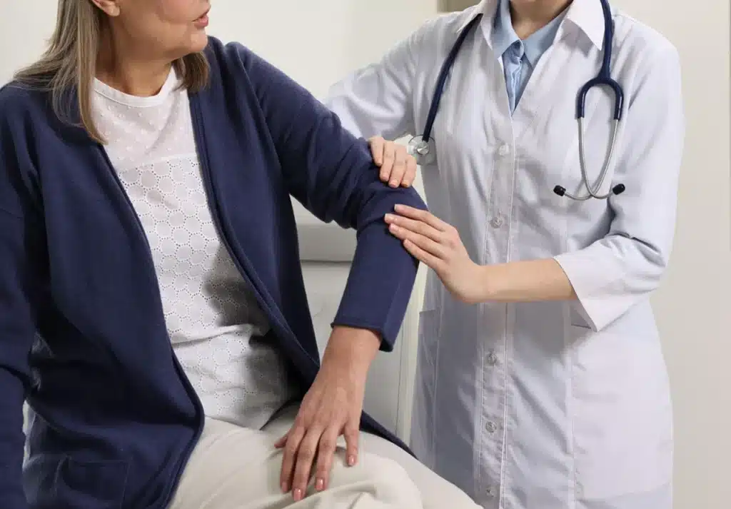 A doctor examines a patient's arm during a medical appointment.